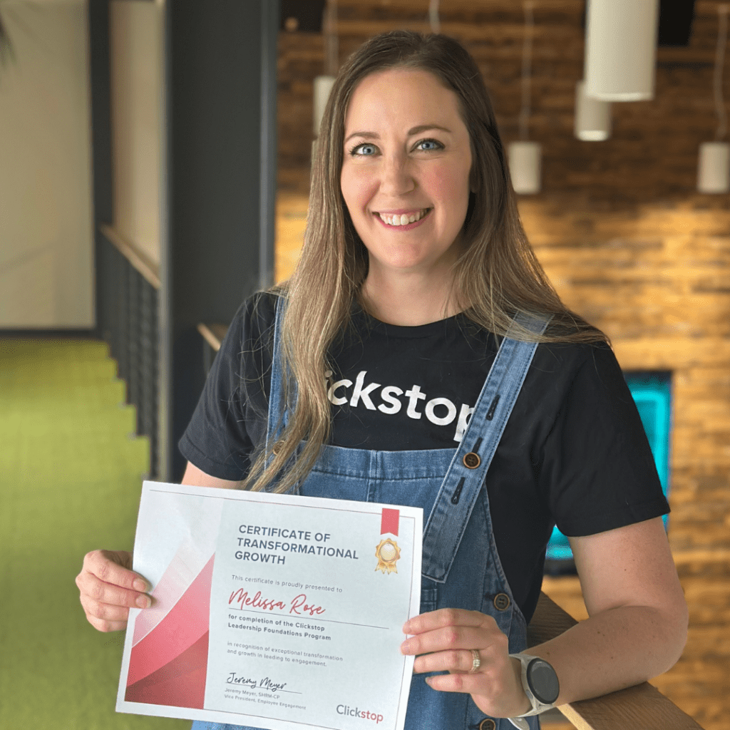Photo of Melissa Rose hold her certificate after completing Clickstop's internal Leadership Foundations Program.